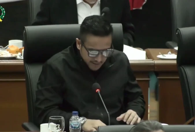 Thopaz berbicara melalui mikrofon di meja rapat anggaran.
